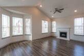 Located at 4415 Andrews Hwy in Midland, Texas, this single-story property offers a well-designed layout with quality finishes throughout. The living room serves as a central highlight, showcasing soaring vaulted ceilings, a ceiling fan, and a white-mantled fireplace. Multiple windows fitted with blinds allow generous natural light to fill the space, while rich, dark wood-look flooring adds warmth and continuity across the main living and kitchen areas.

The kitchen is thoughtfully appointed with dark, stained wood cabinetry extending to the ceiling for ample storage, granite countertops, a tiled mosaic backsplash, and a peninsula with an undermount sink. Stainless steel appliances, including a range, microwave, and dishwasher, are complemented by a black refrigerator. Stylish pendant lighting adds a finishing touch above the peninsula.

The bathrooms feature matching dark cabinetry, granite vanity tops, wood-look tile flooring, and tiled tub-shower combinations with mosaic accent borders. The bedrooms are carpeted for comfort, each equipped with ceiling fans and windows offering neighborhood views. Overall, the space presents a cohesive, modern aesthetic with durable, well-coordinated finishes throughout.