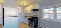Located at 141 Cleveland St in Orange, NJ, this single-floor unit offers a well-organized layout with a clean, modern aesthetic throughout. The interior is finished with warm hardwood flooring that extends across the living and kitchen areas, adding a sense of continuity and warmth to the space.

The kitchen is efficiently designed and equipped with white shaker-style cabinetry, a white subway tile backsplash, a stainless steel gas range, and a full-size refrigerator. A built-in range hood, under-cabinet storage, and a single-basin sink with a window nearby provide both functionality and natural light. The transition between the kitchen tile and the hardwood flooring delineates the cooking space from the open living area.

The living area is open and airy, painted in a soft blue-gray tone that lends a calm, neutral ambiance. A large window allows natural light to fill the room, while a baseboard heating unit ensures year-round comfort. The polished hardwood floors reflect the light beautifully, enhancing the sense of openness.

The bathroom is neatly appointed with a white vanity, mirrored medicine cabinet with overhead lighting, a full soaking tub with a tile surround, and a coordinating tile floor. The consistent gray and white color palette keeps the space feeling fresh and orderly throughout.