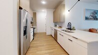 Located at 806 16th Ave N in Nashville, TN, this thoughtfully designed two-bedroom, two-bathroom residence offers a clean, modern aesthetic throughout its well-utilized single-floor layout. Light wood-tone flooring flows seamlessly through every room, creating a warm and cohesive feel.

The galley-style kitchen is a standout feature, outfitted with two-tone cabinetry — crisp white lower cabinets paired with natural wood uppers — complemented by a white quartz countertop, a mosaic tile backsplash, matte black fixtures, and a full suite of stainless steel appliances including a refrigerator, range, microwave, and dishwasher. A modern pendant light adds a stylish finishing touch.

Both bedrooms are bright and comfortable, benefiting from large windows that invite ample natural light. Ceiling fans are present in each room. The primary bedroom connects to a sleek en-suite bathroom featuring a double-sink vanity with quartz countertops, a large mirror, and matte black hardware. A generously sized walk-in closet with wire shelving serves the primary suite, while a second walk-in closet provides additional storage. The second bathroom includes a tub-shower combination with matte black fixtures. The residence also features a private balcony, ideal for outdoor relaxation.