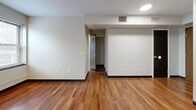 Located at 1990 Ford Drive in Cleveland's 44106 zip code, this one-bedroom, one-bathroom unit offers a practical and well-appointed single-floor layout. The open-concept kitchen and living area serves as the heart of the unit, featuring warm hardwood flooring, rich walnut-toned cabinetry, and a full suite of stainless steel appliances including a gas range, built-in microwave, refrigerator, and dishwasher. The kitchen flows seamlessly into the living space, creating a versatile area for both dining and relaxation. A hallway connects the main living zone to the private quarters, which include two closets and a utility room for added storage and convenience. The spacious primary bedroom is finished with plush carpeting and features a window that brings in natural light and neighborhood views. A second carpeted room, also with a window, offers flexibility as an additional bedroom or office space. The bathroom includes a full soaking tub with classic white tile surround and a window for ventilation. Throughout the unit, clean white walls, dark baseboards, and consistent flooring choices lend a cohesive, modern feel. Ceiling-mounted light fixtures illuminate each room effectively, completing this functional and comfortable Cleveland residence.