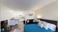 Located at 3531 Wake Forest Rd in Raleigh, NC, this studio unit offers a thoughtfully arranged single-floor layout that maximizes every inch of available space. The open-concept design seamlessly connects the sleeping area and kitchen, creating a cohesive and functional living environment.

The generously sized main living and sleeping area features warm hardwood-style flooring, neutral walls, and a textured ceiling. A large window allows natural light to fill the room, contributing to an airy and welcoming ambiance. An open closet with shelving provides convenient storage directly within the living space.

The kitchen is positioned along one wall and features white cabinetry, a full-size refrigerator, a stovetop, a microwave, and a single-basin sink with a laminate countertop. A half-wall partition subtly separates the kitchen from the main living area while maintaining the open feel of the space.

The bathroom is clean and straightforward, outfitted with a combined tub and shower unit, a toilet, and hardwood-style flooring that ties in with the rest of the unit. The bright white walls give the bathroom a crisp, well-maintained appearance.

Overall, this studio presents a practical and comfortable layout, ideal for those seeking an efficient living space in a convenient Raleigh location.