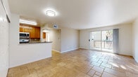 Located at 9601 Reseda Blvd in the Northridge neighborhood of Los Angeles, this one-bedroom, one-bathroom residence offers a well-organized, single-level layout with a cohesive and functional design throughout. The living area is open and airy, finished with warm travertine stone tile flooring that extends seamlessly across the entire unit, lending a sense of continuity and understated elegance. Large sliding glass doors flood the main living space with natural light and open onto a private balcony, offering a pleasant outdoor retreat with views of surrounding greenery. The kitchen features warm wood cabinetry, a dark granite countertop, and a tile backsplash, with a pass-through counter connecting it conveniently to the living area. The spacious bedroom is bright and inviting, benefiting from a large window that draws in natural light, and includes a closet with paneled double doors for generous storage. The bathroom is neatly appointed with matching wood vanity cabinetry, a granite countertop, a combined tub and shower enclosed by sliding glass doors, and built-in shelving for added storage. Clean white walls and neutral tones throughout the unit create a calm, versatile ambiance well-suited to a variety of living styles.
