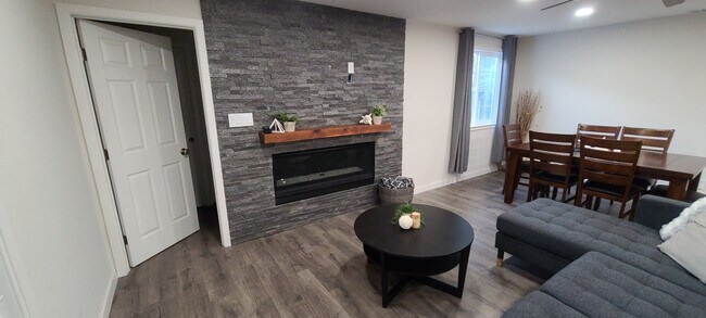 Sala de estar con pared de chimenea de piedra - 514 Osborn Ln