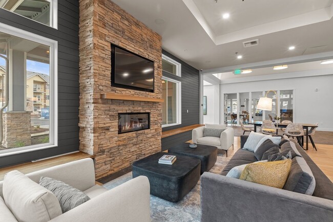 The Modera Lacey resident clubhouse with a modern fireplace and lounge seating is where modern elegance meets cozy warmth. - Modera Lacey