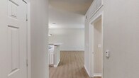 Located at 5750 Forest Park Rd in Dallas, TX, this one-bedroom, one-bathroom unit offers a well-organized single-floor layout designed for comfortable everyday living. Light wood-style flooring runs throughout the main living areas, complemented by neutral wall tones that create a clean, cohesive aesthetic.

The kitchen is a standout feature, equipped with white cabinetry, a suite of white appliances including a range, microwave, and refrigerator, and a peninsula with a double-basin sink. A pendant light above the peninsula adds a focused design touch. Adjacent built-in shelving and a dedicated pantry provide ample storage options.

The living area is bright and airy, featuring a ceiling fan and a sliding glass door that opens to a private balcony with outdoor views of surrounding greenery. The bedroom is generously proportioned, finished with plush carpet and a ceiling fan. A distinctive bay window configuration invites abundant natural light and frames outdoor views, while an additional window further enhances the sense of openness. The bedroom connects conveniently to the rest of the unit.

The bathroom features wood-style flooring, a vanity with light cabinetry and a white countertop, a wall-mounted medicine cabinet, and a full tub-shower combination. A dedicated closet completes the layout, offering practical storage within easy reach of the bedroom.