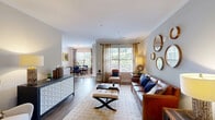 Located at 2905 Chastain Meadows Pkwy in Marietta, GA, this well-appointed 2-bedroom, 2-bathroom single-floor home offers a thoughtfully designed layout with stylish finishes throughout. Rich hardwood-style flooring and crown molding detail the main living areas, setting an elegant tone from the moment you enter through the welcoming hallway.

The open-concept living and dining area is bathed in natural light from large windows dressed with decorative curtains, offering pleasant outdoor views of lush greenery. The living room provides generous space for comfortable seating arrangements, while the adjacent dining area features its own window with vibrant botanical drapery, creating a warm and inviting atmosphere for entertaining.

The kitchen is a standout feature, showcasing dark espresso cabinetry, granite countertops, stainless steel appliances, a center island, and a tile backsplash — combining both functionality and aesthetic appeal.

Both bedrooms are well-sized, with the primary bedroom offering ample space, a ceiling fan, and closet storage. The second bedroom is equally comfortable, featuring dual windows with natural light. Each bathroom is finished with granite vanity tops and glass-enclosed showers.

A dedicated in-unit laundry room with full-size washer and dryer adds everyday convenience, completing this carefully designed home.