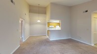 Located at 700 Martin Creel Blvd in Summerville, SC, this single-story unit offers a well-organized layout with a range of functional features throughout. The living room serves as the centerpiece of the home, distinguished by soaring vaulted ceilings that create an open, airy atmosphere. A tile-surround fireplace anchors one wall, while a sliding glass door opens to an outdoor deck, allowing natural light to fill the space and providing views of surrounding greenery. A pendant light near the kitchen pass-through adds a subtle design detail.

The galley-style kitchen is efficiently designed with warm oak cabinetry, white appliances including a coil-top range, refrigerator, and dishwasher, along with a double basin sink and light tile flooring. A skylight-style ceiling panel brightens the space. Louvered bifold doors lead to an interior closet or utility area.

The bedrooms feature neutral carpet and windows with blinds. One bedroom includes direct access to an adjoining space. Both bathrooms are finished with white vanities, large mirrors, light tile flooring, and full-size soaking tubs with surround panels and shower curtain rods, providing practical, clean accommodations throughout the home.