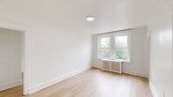Located at 2217 N 51st Street in Philadelphia's 19131 neighborhood, this two-bedroom, one-bathroom unit offers a clean, modern aesthetic across a single floor. Light hardwood flooring runs throughout the entire space, complementing the bright white walls and trim that give each room an open, airy feel.

The renovated kitchen is thoughtfully designed with white shaker-style cabinetry featuring matte black hardware, marble-look quartz countertops, a stainless steel sink with a black gooseneck faucet, and a gas range. A large window above the counter fills the kitchen with natural light and provides views of the surrounding neighborhood.

The primary bedroom is generously proportioned and features a large window with neighborhood views, a classic radiator, and ample wall space. The second bedroom is similarly bright, with a window, radiator, and a closet, making it well-suited as a guest room or home office.

The bathroom maintains the home's clean, white palette with subway tile surrounding a full soaking tub and shower, a pedestal-style vanity with a mirror, and wood-look flooring. Every detail reflects a fresh, well-executed renovation. The unit's consistent use of light tones and natural light creates a cohesive and welcoming atmosphere throughout.