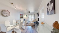Located at 900 Dilworth St in Saint Marys, Georgia, this well-appointed 2-bedroom, 3-bathroom single-floor residence offers a thoughtfully designed layout that maximizes comfort and functionality. A welcoming entrance hallway with wood-look flooring leads into the combined living and dining area, which serves as the heart of the home. The bright living room features crown molding, a ceiling fan, and a sliding glass door that opens onto a private balcony — an ideal spot for relaxing outdoors. Track lighting and large windows allow natural light to fill the dining area, which comfortably accommodates a full dining set. The kitchen is equipped with rich, warm-toned wood cabinetry, white quartz countertops, stainless steel appliances including a dishwasher, and tile flooring, with a window providing additional natural light. Both bedrooms are carpeted and include ceiling fans, ample closet space, and windows overlooking the surrounding neighborhood. The primary bedroom is generously proportioned and benefits from an en-suite bathroom featuring warm wood vanity cabinetry and white countertops. Three bathrooms in total ensure convenience for residents and guests alike. A dedicated laundry area and multiple closets throughout round out the practical offerings of this comfortable Georgia home.