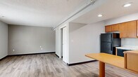 Located at 2084 S Hamilton Rd in Columbus, Ohio, this one-bedroom, two-bathroom unit offers a thoughtfully organized single-floor layout that maximizes every square foot. Light gray walls and wood-look vinyl plank flooring run throughout, creating a clean, cohesive aesthetic.

The open-concept kitchen and dining area serves as a functional hub of the unit. The kitchen is equipped with warm honey-toned wood cabinetry, light marble-style countertops, a full suite of black appliances including a refrigerator, dishwasher, electric range, and over-the-range microwave, as well as a built-in plate rack for added storage. A dining table fits neatly adjacent to the kitchen, making efficient use of the shared space.

The living room offers an open, unobstructed area with a textured ceiling, recessed lighting, and a sliding barn-style door that leads to the bedroom — adding a modern, space-conscious design touch. Two closets provide ample storage throughout the unit.

The primary bedroom is a comfortable, well-proportioned retreat. One full bathroom features a clean white tub-shower combo with chrome fixtures, while a second bathroom showcases a wide vanity with rich wood cabinetry, a granite-style countertop, and a large wall mirror with overhead lighting. Both bathrooms continue the vinyl plank flooring. A utility room rounds out the layout, adding practical functionality to the space.