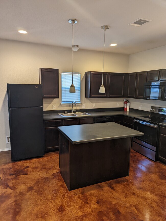 Cocina con muchos gabinetes y una isla. - 13034 Oconnor Cv