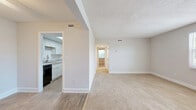 Located at 717 S Beach St in Daytona Beach, Florida, this two-bedroom, one-bathroom residence offers a well-organized single-floor layout designed for comfortable everyday living. The open living room features neutral-toned carpet, a textured ceiling, and a front-facing window that allows natural light to fill the space, creating a bright and welcoming atmosphere. The kitchen is efficiently designed with white cabinetry, light granite-style countertops, a double stainless steel sink, wood-look flooring, and black appliances including a dishwasher and electric range, providing ample functionality. A hallway connects the living areas to the private quarters, maintaining a clean flow throughout. The spacious primary bedroom features two windows overlooking lush greenery, soft carpeting, a ceiling fan, and a walk-in closet with built-in shelving. The second bedroom also features carpeting, a ceiling fan, and a bifold-door closet with a hanging rod. The full bathroom includes a tiled tub-shower combination with brushed nickel fixtures. Consistent neutral wall tones, textured ceilings, and a mix of carpet and wood-look flooring throughout give the residence a cohesive, clean aesthetic suited for a variety of lifestyles.