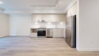 Located at 902 Lytton Street in North Vancouver, BC, this thoughtfully designed three-bedroom, two-bathroom unit offers a clean, contemporary aesthetic across a single level. Light-toned engineered hardwood flooring runs throughout, creating a cohesive and bright atmosphere in every room.

The kitchen is a standout feature, equipped with stainless steel appliances including a range, dishwasher, and refrigerator. Light wood cabinetry with ample upper and lower storage is complemented by a striking marble-effect backsplash and white quartz countertops. Track lighting overhead ensures excellent illumination across the workspace.

The bedrooms are finished with the same light wood flooring and crisp white walls, offering a clean and versatile canvas. The primary bedroom benefits from natural light through a window, while the additional bedrooms are efficiently laid out with sliding and hinged door access. Multiple electrical outlets are conveniently positioned throughout.

Both bathrooms are finished in a minimal, modern style featuring full-height white tile surrounds, soaker tubs, and neutral tile flooring. A well-connected hallway links all rooms, contributing to a practical and functional floor plan. The overall design emphasizes clean lines, neutral tones, and modern finishes throughout.