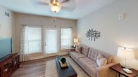 Located in Fort Mill, SC, this single-floor residence offers a thoughtfully designed layout with modern finishes throughout. The kitchen is a standout feature, equipped with rich dark cabinetry, granite-style countertops, a classic subway tile backsplash, and a full suite of stainless steel appliances including a range, microwave, and refrigerator. A large island with pendant lighting provides additional prep space and casual seating.

The living area is bright and welcoming, with wood-style flooring, neutral walls, and large windows and glass doors that invite natural light and outdoor views. A ceiling fan adds both comfort and style to the space.

The primary bedroom offers a serene retreat with plush carpet, soft neutral tones, and a ceiling fan, while the en-suite bathroom features a dual-sink vanity with dark cabinetry, a large mirror, and bright vanity lighting. A generously sized walk-in closet with wire shelving provides excellent storage capacity.

A second bedroom benefits from natural light through a large window with outdoor views. The second full bathroom mirrors the refined design of the primary bath, with a single-sink vanity and a shower-tub combination. Throughout, the space maintains a clean, contemporary aesthetic with cohesive finishes and a comfortable, functional flow.