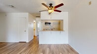 Located on Vincennes Street in the Northridge neighborhood of Los Angeles, this one-bedroom, two-bathroom unit offers a thoughtfully laid-out single-floor living space. The open-concept living and kitchen area serves as the heart of the home, featuring warm wood-look flooring that extends throughout. A ceiling fan with an integrated light fixture adds both comfort and a functional design element to the main living area.

The kitchen is efficiently designed with a peninsula countertop that opens toward the living space, creating a natural flow between cooking and entertaining areas. White cabinetry, a gas range, over-the-range microwave, and a stainless steel sink complete the functional kitchen setup.

The bedroom is a well-proportioned, private retreat with a large sliding window that invites natural light and frames a view of mature palm trees and neighborhood greenery — a classic Southern California backdrop. The clean white walls and wood-look flooring carry through consistently.

Two bathrooms provide added convenience, each finished with light cabinetry, neutral countertops, and wood-look flooring. Textured ceilings are present throughout the unit. The overall aesthetic is clean, neutral, and move-in ready, offering a practical and comfortable living environment in a well-established Los Angeles neighborhood.