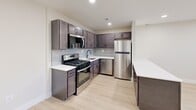 Located at 251 S Olds Blvd in Fairless Hills, PA, this single-floor, one-bedroom, one-bathroom unit offers a thoughtfully designed layout making excellent use of its space. The kitchen is a standout feature, showcasing rich dark-toned shaker-style cabinetry paired with crisp white countertops and a subtle gray subway tile backsplash. A full suite of stainless steel appliances — including a gas range, built-in microwave, dishwasher, and refrigerator — completes the space, all set atop light-toned hardwood-style flooring that adds warmth throughout. The generously sized bedroom is finished with plush gray carpeting and features a bright window that invites natural light, along with convenient access to a dedicated closet. The bathroom is clean and modern, finished with large-format neutral tile surrounding a soaking tub and shower combination, accented by sleek matte black fixtures. A dark-toned vanity with a mirror and ample storage rounds out the space. Throughout the unit, neutral walls, clean white trim, and consistent finishes create a cohesive, move-in-ready aesthetic that balances comfort and contemporary style.