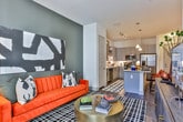 Located in the desirable 30305 zip code of Atlanta, Georgia, this single-floor residence offers a thoughtfully designed open-concept layout that seamlessly connects the kitchen, dining, and living areas. The kitchen is a standout feature, outfitted with grey shaker-style cabinetry extending to the ceiling, granite countertops, a white subway tile backsplash, stainless steel appliances including a refrigerator with ice maker, range, and built-in microwave, as well as under-cabinet lighting. A granite-topped island with bar seating serves as both a functional workspace and casual dining area, anchored by pendant lighting overhead. Track lighting and hardwood-style flooring run throughout the main living space. The living room is bright and welcoming, with large windows allowing generous natural light and views of the surrounding neighborhood. The bedroom features plush carpeting, a bold navy accent wall, a ceiling fan, and ample natural light from a window with blinds. A spacious walk-in closet with wire shelving and hanging rods provides generous storage. The bathroom includes a grey vanity with granite countertop, a tub-shower combination, and hardwood-style flooring, completing this well-appointed Atlanta residence.