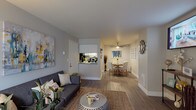 This thoughtfully designed single-floor residence offers a comfortable and functional layout across a variety of well-appointed spaces. The open-concept living and dining area serves as the heart of the home, featuring wood-style flooring, a fireplace, and sliding glass doors that invite natural light and provide outdoor access. The living room offers generous space for seating and relaxation, while the adjacent dining area includes a ceiling fan and seamlessly connects to the pass-through kitchen.

The galley-style kitchen is efficiently organized with white shaker cabinetry, a stainless steel sink, ample counter space, and black appliances including a range and refrigerator — a clean, functional setup for everyday cooking.

The primary bedroom is a serene retreat with plush carpeting, warm neutral walls, and direct access to a private bathroom. The en-suite bath features a vanity with storage and a shower-tub combination. A second bedroom with carpet flooring and natural light offers versatility, currently utilized as a flexible bonus or wellness room. A second bathroom with hardwood-style flooring and a toilet closet rounds out the layout.

Throughout the residence, a cohesive neutral palette, consistent wood-style flooring in main areas, and carpet in bedrooms create a calm, modern ambiance suited for comfortable everyday living.