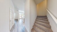 Located at 1659 2nd St in Sarasota, FL, this two-bedroom, three-bathroom two-story residence offers a thoughtfully designed layout spread across two floors. The main level impresses immediately with soaring ceilings that amplify the sense of openness in the living area, where light-toned hardwood-style flooring runs throughout. Large windows and a glass door flood the space with natural light while offering views of the surrounding greenery. The modern kitchen features dark wood cabinetry contrasted by white upper cabinets, stainless steel appliances including a refrigerator and microwave, a sleek island with an integrated sink, and a tile backsplash — all illuminated by track lighting. A convenient half bathroom with tile flooring completes the main level. The upper floor hosts both bedrooms, including a generously sized primary suite with a walk-in closet equipped with wire shelving. The primary bathroom is elegantly appointed with a dual-sink vanity featuring marble-look countertops, tile flooring, and ample storage. A second full bathroom mirrors the same refined aesthetic. The secondary bedroom features plush carpeting and a spacious closet. Throughout, the clean white walls, modern hardware, and consistent finishes create a cohesive, contemporary ambiance ideal for comfortable Sarasota living.