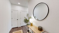 Located at 2025 50th Ave in Greeley, Colorado, this thoughtfully designed two-bedroom, three-bathroom residence offers a clean, modern aesthetic with warm, contemporary finishes throughout. The open-concept kitchen and living area serves as the heart of the home, featuring light wood cabinetry, a quartz waterfall peninsula with bar seating, stainless steel appliances, subway tile backsplash, and pendant lighting. A sliding glass door floods the kitchen with natural light and provides access to an outdoor space. Built-in shelving adds functional character to the dining area. The living room is bright and airy, with large corner windows dressed in sheer curtains that invite abundant natural light. Wide-plank hardwood-style flooring flows throughout the entire residence. Both bedrooms are well-appointed and restful, with the primary suite featuring a stylish barn door leading to an en-suite bathroom complete with a dual-sink vanity, a glass-enclosed walk-in shower, and a dedicated closet. The additional bathrooms continue the cohesive design with light wood vanities, modern matte black hardware, and clean neutral palettes. Every detail of this residence reflects a commitment to modern, functional living.
