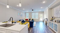 Located in Olathe, Kansas, this two-story home offers a thoughtfully designed layout across two well-proportioned floors. The main level opens into a bright living room featuring wood-look flooring, crown molding, recessed lighting, a ceiling fan, and a striking shiplap feature wall housing a sleek linear fireplace. Large windows and a glass-panel door flood the space with natural light and provide outdoor views, while a kitchen counter with seating flows seamlessly into the living area. Three clean, modern bathrooms serve the home, each finished with white shaker-style cabinetry, wood-look flooring, and black hardware accents. One bathroom features a glass-enclosed walk-in shower with wood-toned tile surround. The upper level hosts two bedrooms, each equipped with ceiling fans and carpeted floors. The primary bedroom is a generous retreat, accompanied by a well-organized walk-in closet with built-in shelving, hanging rods, and dedicated storage sections. The second bedroom offers flexible use as a home office or guest room, with a window overlooking greenery. Throughout, a neutral color palette, consistent finishes, and thoughtful details create a cohesive and comfortable living environment across both floors.