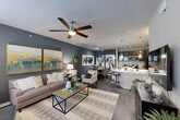 Located at 23400 Kingsland Blvd in Katy, TX, this thoughtfully designed one-bedroom, one-bathroom residence offers a cohesive open-concept layout that seamlessly connects the living, dining, and kitchen areas. Rich hardwood-style flooring flows throughout the main living spaces, complemented by bold slate-blue accent walls and ceiling fans that enhance the modern aesthetic.

The kitchen is a standout feature, boasting dark espresso cabinetry, gleaming white quartz countertops, stainless steel appliances including a range, microwave, and refrigerator, and a breakfast bar with pendant lighting — ideal for both casual dining and entertaining. A large wall mirror in the dining area amplifies the sense of space and light.

The living room is bright and welcoming, with multiple windows allowing natural light to pour in, and ample room for comfortable seating arrangements. The bedroom continues the refined design with plush carpet, a striking accent wall, built-in shelving, and generous natural light. Two closets, including a well-organized walk-in, provide excellent storage.

The bathroom features clean tile flooring, a full vanity with modern fixtures, and an in-unit washer and dryer — adding exceptional everyday convenience to this polished Houston-area residence.