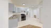 This 540 square foot apartment in Chicago offers a compact yet functional living space. The unit features an unusual layout with two bedrooms, one bathroom, and surprisingly, two kitchen areas. The primary bedroom measures 120 square feet, providing a cozy retreat.

The main living area showcases an open-concept design, with a kitchen that flows into the living room. The kitchen is equipped with light gray cabinetry, a gas stove, and a stainless steel sink, all set against white walls and tiled flooring. Recessed lighting illuminates the space effectively.

The bathroom, though compact, is well-appointed with a white vanity, toilet, and a shower/tub combination. Beige tiled walls and flooring create a clean, neutral aesthetic.

Both bedrooms feature plush carpeting and windows that allow natural light to filter in. Built-in closets offer ample storage space. The overall design aesthetic is minimalist and modern, with a predominantly white color scheme that makes the space feel larger and brighter.

The apartment's unique floor plan, as seen in the 3D model, reveals an efficient use of space. Despite its small footprint, the layout manages to incorporate all essential living areas without feeling cramped. This property at 7131 S Yates Blvd in Chicago's 60649 zip code is ideal for those seeking a low-maintenance, urban lifestyle in a well-designed, compact space.