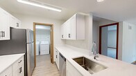 Located at 4695 Aldun Ridge Ave NW in Comstock Park, Michigan, this single-floor, 2-bedroom, 2-bathroom home offers a clean, functional layout with modern finishes. The open kitchen is a standout feature, showcasing white shaker cabinetry with matte black hardware, light quartz countertops, a stainless steel undermount sink, and stainless steel appliances including a refrigerator, range, and dishwasher. The kitchen flows seamlessly into the living room, which is finished with warm-toned luxury vinyl plank flooring and features a sliding glass door that fills the space with natural light and provides direct access to a patio with outdoor views. Both bedrooms are carpeted and offer a quiet, comfortable retreat, with the primary bedroom providing generous proportions and a well-sized closet. The secondary bedroom includes a built-in sliding wood closet. Each bathroom features white vanity cabinetry, quartz countertops, tile flooring, and a tub-shower combination. A dedicated in-unit laundry room with a full-size washer and dryer adds everyday convenience. Light-toned walls, wood-trimmed doorways, and consistent finishes throughout lend the home a cohesive and well-maintained character.