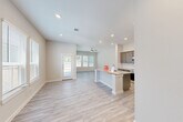 Located at 22804 Frassino Place in Katy, TX, this two-story home offers a well-designed layout across two floors. The main level features an open-concept living and dining area with light wood-style flooring, a ceiling fan, and windows that bring in natural light along with views of the backyard through a glass-panel door. The kitchen is a standout space, equipped with rich dark wood cabinetry, granite countertops, a central island with a sink, stainless steel appliances including a French door refrigerator and built-in microwave, and open shelving for additional storage. A convenient half bath with a pedestal sink is also located on the main floor. Upstairs, the home hosts three bedrooms, including a spacious primary bedroom with plush carpeting and a dedicated en-suite bathroom. The additional bedrooms are finished with neutral carpet and share access to a full bathroom featuring a tiled tub-shower combination with sliding glass doors. A generous walk-in closet with dual hanging rods provides ample storage. The upper floor also includes a dedicated laundry room with shelving above the washer. Throughout the home, neutral tones and clean finishes create a bright and cohesive living environment.