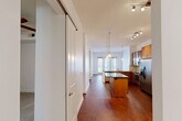Located at 2800 Kirby Drive in Houston's desirable Upper Kirby neighborhood, this well-appointed 2-bedroom, 2-bathroom unit offers a thoughtfully designed single-floor layout with a generous overall footprint. The open-concept kitchen is a standout feature, showcasing rich wood cabinetry, granite countertops, a tile backsplash, stainless steel appliances including a French door refrigerator and electric range, and pendant lighting over both a breakfast bar and a secondary island with a dark countertop. Hardwood flooring flows throughout the main living and kitchen areas, adding warmth and continuity to the space. The primary bedroom is a comfortable size, featuring plush carpeting, a ceiling fan, and multiple windows that invite natural light. The second bedroom also offers carpeted flooring, a window with exterior views, and direct access to an outdoor area. Both bathrooms are finished with large-format tile surrounds and soaking tubs with shower combinations. A dedicated laundry room houses a full-size front-loading washer. Two closets provide ample storage, while two hallways connect the layout efficiently. The unit's clean, neutral palette and consistent finishes create a cohesive and functional living environment.
