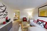 Located at 90 Uvalde Rd in Houston, TX, this one-bedroom, one-bathroom residence offers a well-organized single-floor layout designed to maximize every square foot. The open living and dining area serves as the heart of the home, featuring soft neutral walls, plush carpeting, and generous wall space ideal for artwork and décor. The living room accommodates a comfortable seating arrangement centered around a glass-topped coffee table, while a dedicated dining nook provides an intimate setting for meals. The galley-style kitchen is efficiently laid out with white cabinetry, ample counter space, a double-basin sink, and tile flooring — offering a clean and functional cooking environment. The spacious bedroom features a ceiling fan, a large window that brings in natural light, and plush carpet underfoot, creating a calm and restful retreat. Two closets provide practical storage throughout the unit. The bathroom includes a vanity with under-sink storage, a well-lit mirror, and tile flooring. A private patio extends the living space outdoors, adding an additional area for relaxation. A hallway connects the key areas of the home, completing this thoughtfully arranged single-story residence.
