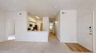 This single-story, 2-bedroom, 2-bathroom residence offers a thoughtfully designed layout that maximizes functionality and comfort. The open-concept living and kitchen area serves as the heart of the home, where warm wood-look flooring flows throughout. The kitchen is outfitted with stainless steel appliances, including a gas range, built-in microwave, and dishwasher, complemented by light gray shaker-style cabinetry, a white subway tile backsplash, and a peninsula that provides additional prep and seating space.

The living area features plush carpet flooring, crown molding, and abundant natural light streaming through large windows and sliding glass doors that brighten the space. The primary bedroom is generously sized, offering a ceiling fan, a walk-in closet with wire shelving, and a private en-suite bathroom. The second bedroom is also carpeted and well-lit with natural light. Both bathrooms feature light wood-look flooring, white vanities, and clean, classic finishes, with the secondary bath including a full tub-shower combination.

Additional highlights include a dedicated laundry room with hookups and a water heater, as well as three closets throughout the residence providing excellent storage capacity. The overall aesthetic is bright, neutral, and move-in ready.