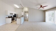 This single-story, 3-bedroom, 2-bathroom home offers a practical and comfortable layout across one level. The open living area immediately impresses with vaulted ceilings and a ceiling fan, creating an airy and spacious atmosphere. Plush carpeting flows throughout the living and bedroom areas, while light-toned ceramic tile defines the kitchen and wet areas.

The kitchen is well-equipped and functional, featuring white cabinetry, dark granite-style countertops, stainless steel appliances including a refrigerator, electric range, built-in microwave, and dishwasher. A peninsula counter opens toward the living area, enhancing the sense of connectivity between spaces. Track lighting above the kitchen provides ample illumination.

The primary bedroom is generously sized with a walk-in closet outfitted with wire shelving for organized storage. The additional bedrooms are comfortably proportioned, each with soft carpeting and windows that invite natural light and outdoor views. The two bathrooms are clean and efficiently designed, with one featuring a full tub-shower combination and tile flooring.

A dedicated laundry room accommodates a full-size side-by-side washer and dryer, adding everyday convenience. The hallway connects the rooms efficiently, and multiple closets throughout the home provide ample storage. The living room includes a sliding glass door with vertical blinds, allowing for natural light and outdoor access.
