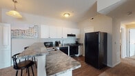 Located at 882 Taylor Station Rd in Gahanna, Ohio, this single-floor unit offers a well-organized, functional layout across multiple rooms. The kitchen is outfitted with white shaker-style cabinetry, dark granite-style countertops, and a full suite of black appliances including a refrigerator, electric range, dishwasher, and microwave. A peninsula with bar seating adds versatility, while hardwood-style flooring grounds the space with warmth and durability. The living room features plush carpeting, a textured ceiling, and a glass-paned door that provides natural light and access to an outdoor area. The unit includes multiple carpeted bedrooms, each with neutral-toned walls and windows that allow natural light to filter in. One bedroom features a walk-in closet, offering generous storage. The unit is served by two bathrooms: one with a standalone walk-in shower and a single-sink vanity with dark countertops, and a second with a shower-tub combination and matching dark countertop vanity, both finished with hardwood-style flooring. Throughout the unit, a consistent neutral color palette and practical finishes create a clean, cohesive aesthetic well suited for comfortable, everyday living.