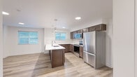 Located at 12531 N Kenosha Ln in Rathdrum, Idaho, this single-floor, 3-bedroom, 2-bathroom unit offers a well-designed layout with contemporary finishes throughout. The open-concept kitchen and living area serves as the heart of the home, anchored by a central island with a white quartz countertop, undermount sink, and pendant lighting. Rich dark-brown cabinetry pairs with a classic tile backsplash and a full suite of stainless steel appliances, including a refrigerator, range, and built-in microwave. Wood-style plank flooring flows seamlessly throughout the entire unit, adding warmth and visual continuity. The living area is bright and open, benefiting from multiple windows fitted with blinds that invite natural light while offering privacy. Each of the three bedrooms is well-proportioned, with the primary bedroom offering generous space, and secondary bedrooms featuring large windows with exterior views and ample closet storage with sliding doors. The bathrooms are cleanly finished with tile flooring, dark wood vanities with quartz countertops, and a tub-shower combination with built-in shelving. A dedicated laundry area houses a stacked Whirlpool washer and dryer. A wall-mounted mini-split unit provides efficient climate control in one of the bedrooms.