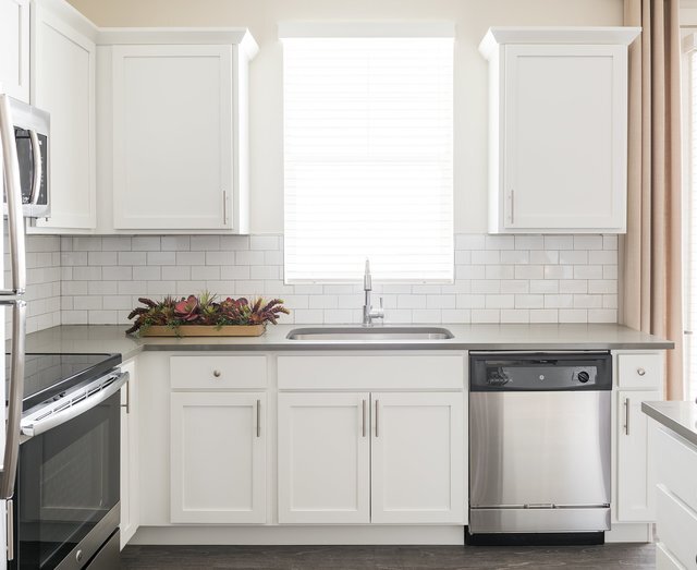 White Cabinetry In Kitchen with Stainless Steel Appliances - Rivulet Apartments