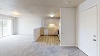 Located at 2801 Montaluma Dr in Springfield, Illinois, this single-floor unit offers a practical and comfortable layout designed for everyday living. The open-concept living and kitchen area forms the heart of the home, where light-toned cabinetry, a double-basin sink, and a full suite of appliances — including a stove, dishwasher, and refrigerator — are neatly arranged along the kitchen perimeter. Light wood-style flooring in the kitchen transitions to soft wall-to-wall carpeting in the living area, creating a warm and welcoming atmosphere throughout. A half-wall peninsula separates the kitchen from the spacious living space, enhancing the open feel while maintaining a sense of definition between the two areas. The bedrooms are carpeted and feature neutral walls, textured ceilings, and ample natural light from windows fitted with blinds. At least one bedroom includes a generously sized walk-in closet with built-in lighting, providing excellent storage. The bathroom is finished with light wood-style flooring and includes accessibility-friendly grab bars, reflecting thoughtful design. Throughout the unit, crisp white trim, panel doors, and a consistent neutral color palette contribute to a clean, move-in-ready aesthetic.