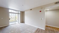 Located at 755 E Capitol Ave in Milpitas, CA, this one-bedroom, one-bathroom residence offers a well-organized single-floor layout designed for comfortable everyday living. The combined kitchen and living room serves as the heart of the home, where wood-look flooring, a granite-topped peninsula, rich dark-stained cabinetry, and stainless steel appliances create a functional and cohesive space. A louvered bifold door conceals an in-unit washer and dryer, adding a practical convenience. The living area is carpeted and bathed in natural light through a large sliding glass door that opens to a private balcony, offering views of the surrounding neighborhood. A connecting hallway with neutral warm-toned walls leads to the remaining rooms. The bedroom is a comfortable retreat, featuring plush carpet, a distinctive arched window that frames outdoor views, and ample wall space. The bathroom is finished with wood-look flooring, a granite-topped vanity with a dark wood cabinet, a full tub-shower combination with tile surround, and a large mirror. Warm beige tones, white trim, and consistent finishes throughout the unit create a clean, cohesive aesthetic.