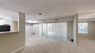 Located at 5505 Tomahawk Dr in Greensboro, NC, this single-floor, 3-bedroom, 2-bathroom home offers a practical and comfortable layout. The combined dining and living area serves as the heart of the home, featuring plush carpeting, a textured ceiling, and a full-width sliding glass door dressed with vertical blinds that flood the space with natural light and provide outdoor views. An adjoining den adds flexible living space to the floor plan.

The kitchen is well-appointed with stainless steel appliances, including a range and over-the-range microwave, complemented by a subway tile backsplash and wood-look flooring. A dedicated walk-in pantry with built-in shelving offers excellent storage and organization.

The three bedrooms are carpeted and finished in neutral tones. The primary bedroom features a ceiling fan with light fixture and a window overlooking greenery, while the additional bedrooms are equally well-sized with easy access to the hallway. Five closets throughout the home ensure generous storage capacity.

The two bathrooms each include a tiled tub-shower combination finished in crisp white, maintaining a clean and functional aesthetic. The home's consistent neutral palette and practical design make it a versatile and move-in-ready residence.