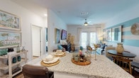 Located at 1730 Northpointe Pkwy in Lutz, Florida, this single-story residence offers a thoughtfully designed open-concept layout that seamlessly connects the kitchen, dining, and living areas. The kitchen is outfitted with crisp white shaker cabinetry, granite countertops, a subway tile backsplash, and a full suite of stainless steel appliances, including a range, microwave, dishwasher, and refrigerator. A generous island with seating provides additional prep and dining space.

The living room is a welcoming area highlighted by wood-style flooring, a ceiling fan, and a bold teal-and-white striped accent wall that adds visual character. French doors allow abundant natural light to fill the space while providing access to an outdoor area. The bedroom features plush carpeting, a ceiling fan, and a teal accent wall that ties into the overall color palette of the home, along with windows that invite natural light. The bathroom includes a tub-shower combination with granite-topped vanity and wood-style flooring. Throughout the residence, the cohesive teal and neutral color scheme, combined with modern finishes, creates a bright and inviting atmosphere.