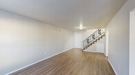Located at 4118 Auburn Road in Memphis, TN, this two-story home offers a practical and comfortable layout across three bedrooms and two bathrooms. The main floor features a welcoming living area finished with warm wood-look laminate flooring, neutral-toned walls, and a textured ceiling. Natural light filters through front-facing windows, brightening the open space. A decorative metal-railed staircase connects the two levels, adding a subtle design accent to the interior. The kitchen is equipped with white cabinetry, a double sink, and includes a refrigerator and range, all set on matching laminate flooring that carries through from the living area. Both bathrooms are finished with tile flooring and feature full tub-shower combinations with white tile surrounds and windows that provide natural ventilation and light. The upper floor hosts the bedrooms, each carpeted in a neutral tone for comfort. The primary bedroom offers a generous footprint with a sliding-door closet, while the additional bedrooms provide ample space with their own closet access and natural light from individual windows. A connecting hallway ties the upper level together efficiently. Throughout, the home presents a clean, move-in ready appearance with consistent neutral finishes.