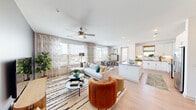 Located at 2001 Plateau Vista Blvd in Round Rock, TX, this well-appointed 2-bedroom, 2-bathroom residence offers a thoughtfully designed single-level layout. A welcoming entryway with light wood-style flooring and a bold accent wall leads into the heart of the home. The open-concept living, dining, and kitchen area is bright and airy, filled with natural light from large windows dressed in sheer, patterned curtains. Ceiling fans add comfort throughout the main living spaces. The kitchen stands out with white shaker cabinetry, a classic subway tile backsplash, quartz countertops, stainless steel appliances, and a central island — ideal for both cooking and entertaining. The dining area enjoys abundant natural light and outdoor views. The spacious primary bedroom features a ceiling fan, generous closet space, and windows overlooking the surroundings. The second bedroom is equally well-proportioned with high ceilings and its own closet. Both bathrooms are finished in clean white tones with quartz vanities and tub-shower combinations. Light wood-style flooring flows throughout the main areas, adding warmth and cohesion to the home's modern, welcoming aesthetic.