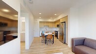 Located at 2555 Research Park Dr in Davis, CA, this well-designed one-bedroom, one-bathroom unit offers a clean, modern aesthetic with light wood-tone flooring and crisp white walls throughout. The open-plan layout seamlessly connects the living room, dining area, and kitchen, creating an efficient and cohesive living space. The kitchen is outfitted with light wood cabinetry extending to the ceiling, white quartz countertops, and a full suite of stainless steel appliances including a refrigerator, range, microwave, and dishwasher. A dining table with seating sits adjacent to the kitchen, ideal for everyday meals. The living room features a window and a glass door that opens onto a private balcony, allowing natural light to fill the space and providing views of the surrounding greenery. The bedroom is a comfortable, well-lit room with a window overlooking mature trees, a ceiling fan, and a sliding closet. The bathroom is finished with white subway tile surrounding a tub-shower combo and features brushed gold fixtures paired with light wood-look flooring. Additional conveniences include in-unit laundry and two closets. The space maintains a consistent modern and minimalist character throughout.