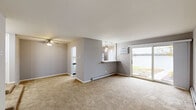 Located at 149 N Milwaukee Ave in Lake Villa, IL, this well-appointed 2-bedroom, 2-bathroom residence offers a comfortable and thoughtfully designed single-floor layout. The open living area is anchored by a large sliding glass door that frames breathtaking waterfront views and provides direct outdoor access to a lakeside patio, filling the space with abundant natural light. Warm neutral carpet and gray-toned walls create a cohesive aesthetic throughout the living and bedroom areas.

The kitchen has been updated with crisp white shaker cabinetry, marble-look quartz countertops, a double-basin sink, and stainless steel appliances including a dishwasher. Wood-look luxury vinyl flooring ties the kitchen and wet areas together seamlessly. A convenient pass-through opening connects the kitchen to the living area.

Both bedrooms are generously proportioned with plush carpeting and large windows, one featuring a window unit AC and a serene wooded view. The primary bedroom includes a dedicated closet. Both bathrooms have been renovated with white vanities, marble-look quartz countertops, modern vessel or undermount sinks, brushed nickel fixtures, and wood-look flooring. The full bath includes a tub-shower combination. A hallway and two closets provide practical storage throughout the unit.