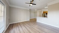 This contemporary apartment in Buford, GA, offers 1,170 square feet of thoughtfully designed living space. The open-concept floor plan seamlessly integrates the kitchen, living, and dining areas, creating an inviting atmosphere for both relaxation and entertainment. The kitchen is a standout feature, boasting sleek wooden cabinetry, stainless steel appliances, and a stylish herringbone backsplash. A large center island with a sink and ample counter space enhances functionality and serves as a focal point for casual dining.

The apartment includes three bedrooms, with the primary bedroom measuring a generous 190 square feet. Two full bathrooms provide convenience for residents and guests alike. The living areas are adorned with modern light fixtures, including ceiling fans for comfort. Large windows and a glass door leading to a balcony or patio allow natural light to flood the space, creating a bright and airy ambiance.

Practicality meets style with durable laminate flooring throughout the main living areas and plush carpeting in the bedrooms. The in-unit laundry room, equipped with a washer and dryer, adds to the apartment's convenience. Crown molding and neutral paint colors throughout lend a sophisticated touch to the overall design. This well-appointed apartment offers a harmonious blend of comfort, style, and functionality in a desirable Buford location.