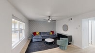 This contemporary 770 square foot apartment in Austin, TX offers a blend of style and functionality. The open-concept layout maximizes the use of space, with a combined dining room and kitchen that flows seamlessly into the living area. The kitchen boasts a modern design with white cabinetry, stainless steel appliances, and a convenient breakfast bar.

The living room is anchored by a plush gray sectional sofa, complemented by a striking geometric wallpaper feature wall. Large windows throughout allow for ample natural light, while ceiling fans in the bedrooms ensure comfort. The primary bedroom, measuring 140 square feet, features a bold red headboard and modern artwork.

The bathroom showcases a clean, minimalist design with a spacious vanity and light wood flooring. Both bedrooms offer cozy spaces with stylish lighting fixtures and ample closet space. The apartment's decor is a tasteful mix of modern and mid-century elements, with unique art pieces and a zebra-print rug adding character.

A standout feature is the dining area, which offers views of the community pool through large windows, perfect for enjoying meals or working from home. The apartment's location at 923 E 41st St puts residents in the heart of Austin, providing easy access to city amenities. With its thoughtful design and desirable features, this apartment offers a comfortable and stylish living experience in a vibrant urban setting.