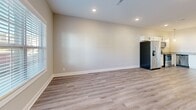 Located at 2500 Tiny Town Rd in Clarksville, TN, this two-story home offers three bedrooms, two bathrooms, and a thoughtfully designed layout spread across two well-proportioned floors. The main level welcomes you with light-toned luxury vinyl plank flooring, neutral warm-beige walls, and recessed lighting that create a bright, open atmosphere. The open-concept kitchen and living area are seamlessly connected, with the kitchen showcasing white shaker cabinetry, granite countertops, stainless steel appliances including a side-by-side refrigerator, electric range, built-in microwave, and dishwasher, as well as stylish pendant lighting over the workspace. Natural light flows in through windows fitted with white plantation blinds. The bathrooms feature clean white cabinetry with matte black hardware, LVP flooring, and a full tub-shower combination with built-in shelving. The upper level hosts the bedrooms, including a generously sized primary bedroom with plush carpeting and a ceiling fan. Each bedroom benefits from well-sized closets with wire shelving for organized storage. The second bathroom offers a wide vanity with a marble-look countertop and a large mirror. Throughout the home, five-panel white doors and clean white trim provide a cohesive, polished finish.