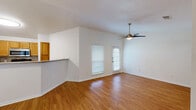 Located at 5501 Sayle St in Greenville, Texas, this single-story, one-bedroom, two-bathroom home offers a well-designed layout that maximizes its compact footprint. The living room is a bright, inviting space highlighted by vaulted ceilings, warm hardwood-style flooring, and a ceiling fan with light kit. Natural light filters in through blinded windows, creating an airy atmosphere, while a door provides convenient exterior access. The kitchen is efficiently appointed with warm wood cabinetry, a tile backsplash, black appliances including a range and refrigerator, a stainless steel microwave, and a peninsula with a granite-look countertop that opens toward the living area — ideal for casual dining or entertaining. The spacious primary bedroom features plush carpeting, a ceiling fan, and a window that lets in ample natural light. The bathroom includes a full tub-shower combo, a wood-cabinet vanity with a granite-look countertop, a large mirror, and tile flooring. A dedicated laundry area with washer and dryer hookups, a utility sink, and a water heater rounds out the home's practical amenities. Throughout, the home maintains a clean, neutral palette that offers a versatile backdrop for any style of furnishing.