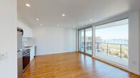 Located at 915 W Grape St in San Diego's Bankers Hill neighborhood, this contemporary single-floor residence offers a clean, modern design with a bright and open layout. Warm hardwood-style flooring runs consistently throughout the entire space, creating a cohesive and inviting atmosphere.

The open-concept living and kitchen area is a standout feature, bathed in natural light through expansive floor-to-ceiling sliding glass doors that lead directly to a private balcony. The balcony provides open views of the surrounding San Diego cityscape, making it an ideal spot for outdoor relaxation. Recessed lighting throughout the ceiling complements the abundant natural light.

The kitchen is efficiently integrated into the main living space and is outfitted with white cabinetry, a stainless steel refrigerator, and a dishwasher, offering a clean and functional aesthetic.

The bedroom is a well-proportioned, private room featuring large windows that invite natural light and views of the surrounding building community. It includes access to a closet, providing practical storage solutions.

The bathroom maintains the home's clean, modern palette with white subway tile lining the tub and shower surround, a white vanity, and matching hardwood-style flooring that ties the space together seamlessly.

Overall, this residence offers a bright, minimalist aesthetic well-suited to contemporary urban living in San Diego.