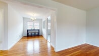 Located at 115 Old Short Hills Rd in West Orange, NJ, this single-floor residence offers a thoughtfully designed layout with a clean, neutral aesthetic throughout. Warm-toned hardwood floors run through the living, dining, and bedroom areas, reflecting natural light and lending a cohesive sense of warmth to the space.

The living area is generously proportioned, with large windows that invite abundant natural light and offer views of the surrounding greenery. Baseboard heating and a wall-mounted AC unit ensure year-round comfort. The dining area, defined by a classic arched entryway, features an elegant chandelier and double windows overlooking the exterior, creating an inviting setting for meals.

The kitchen is well-equipped with rich, dark-stained shaker cabinetry, light stone countertops, a white subway tile backsplash, and a full suite of stainless steel appliances including a gas range, microwave, and dishwasher. Light-toned flooring completes the modern yet functional kitchen design.

The bedrooms are bright and spacious, each with hardwood floors, natural light from well-placed windows, and ample closet space. The bathrooms are finished with dark wood vanities, white countertops, chrome fixtures, and large mirrors, offering a clean and contemporary look. The overall ambiance is bright, tidy, and move-in ready.